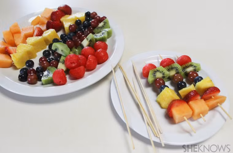 Tiếp tục cắt các loại trái cây to (xoài, kiwi, dưa vàng) thành miếng nhỏ, xiên vào que tre cùng các loại trái cây nhỏ như nho, cherry...