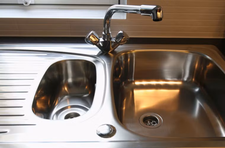 Làm sáng bồn rửa bát kim loại. Chị em hãy rửa kỹ một lần bằng bàn chải. Sau đó, làm sạch bằng giấm rồi tráng lại bằng nước.