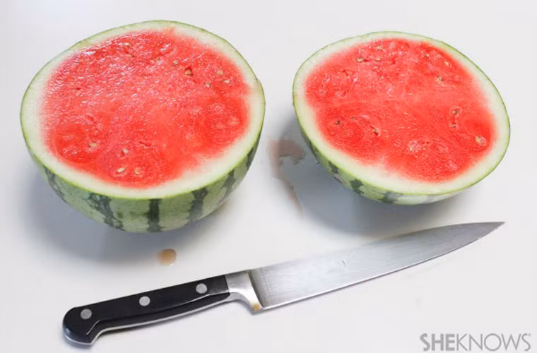 Tiếp đó, bổ dưa làm đôi sao cho phần dùng để làm chân lò nướng lớn hơn so với miếng còn lại.