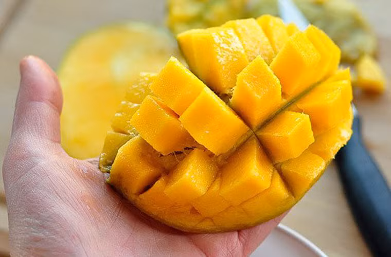 Công việc kế tiếp là lật ngược phần vỏ xoài và tách thịt quả.