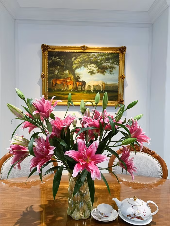 Cô trưng hoa tươi để không gian sống thêm sinh động. Tranh treo tường được chọn khung đồng tông với mặt bàn để không gian hài hòa và sang trọng hơn.