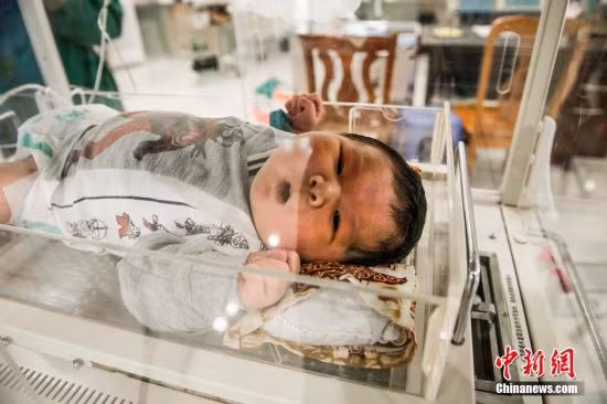 Sau khi sinh đứa bé được đưa vào lồng ấp. Các phóng viên cho rằng so với trẻ sơ sinh nói chung, cậu bé trông giống như một đứa bé vài tháng tuổi, khuôn mặt tròn và mái tóc tương đối nhiều.