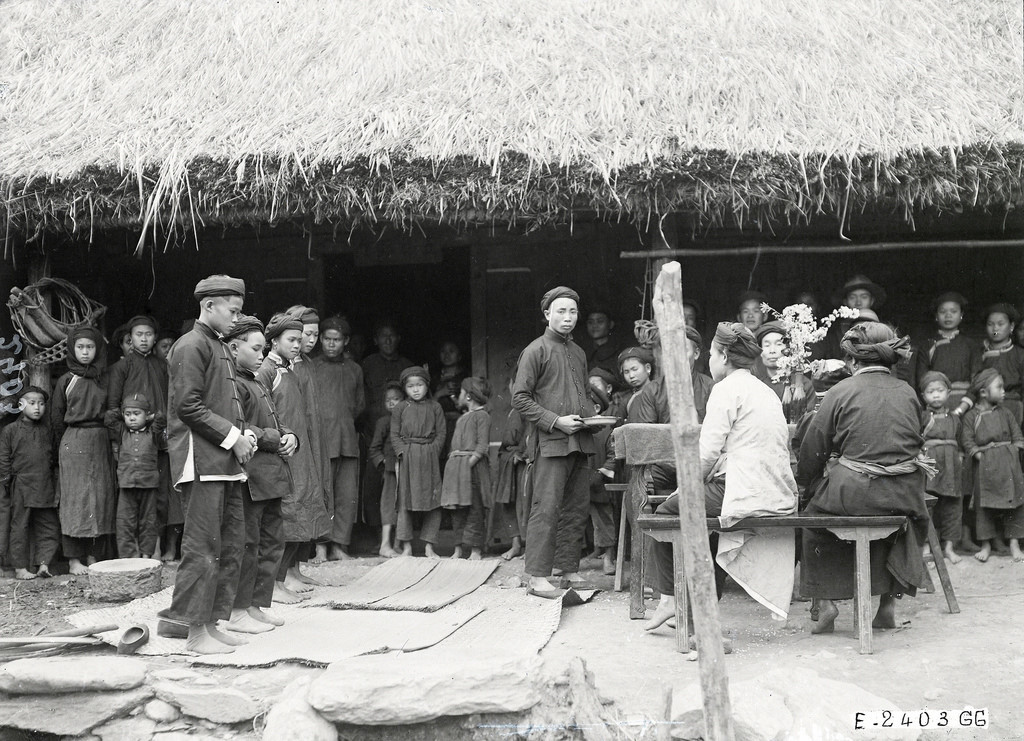 Cô dâu và chú rể nhỏ tuổi được phù dâu và phù rể hỗ trợ bước ra trước mặt bố mẹ cô dâu trong một đám cưới của người Tày ở Bắc Hà, Lào Cai thập niên 1920.