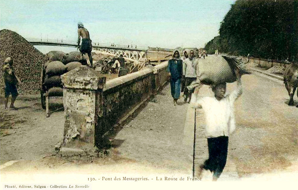 Cận cảnh đường dẫn lên cầu Mống. Khách bộ hành đi trên vỉa hè, xe bò kéo đi dưới lòng đường.