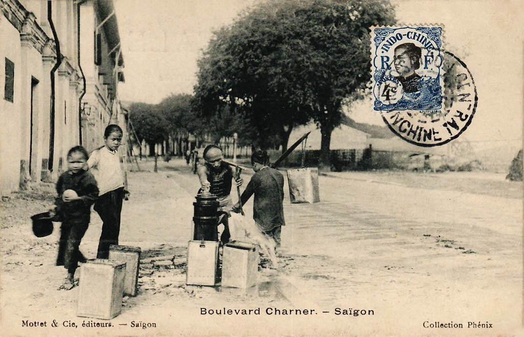 Những người gánh nước ở bến Chương Dương, cầu Mống thấp thoáng ở phía xa, góc phải. Tấm bưu thiếp này chú thích sai địa điểm, là "Boulevard Charner" - đường Nguyễn Huệ ngày nay.