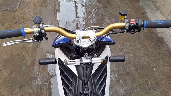 Cùm và ghi đông độ lại với ghi đông trần Aprilia Tuono, chống đỗ trước và trợ lực tay lái.