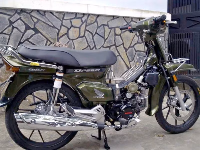 Một chiếc Dream khác độ dàn tem gần giống với màu quân đội hầm hố, đi mâm Raider nổi tiếng và dán tem công nghệ PGM-Fi (công nghệ phun xăng điện tử).