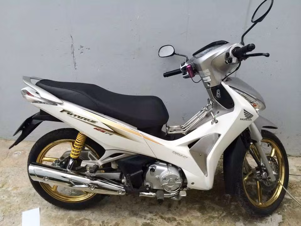 Một chiếc Honda Future 125 Fi trắng bạc long lanh được chủ nhân độ vài món đồ và nổi bật nhất là cặp mâm được mạ vàng 18K khá nặng tay.