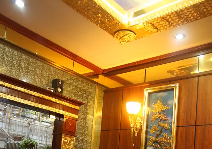 Chi phí để độ vàng cho riêng phòng khách không hề nhỏ và đây có thể là phòng khách đắt tiền nhất Việt Nam bởi sự cầu kỳ và tinh tế cũng như giá trị các vật dụng bên trong. Ảnh: Các góc của trần phòng khách đều được ốp và phủ một lớp vàng ròng.
