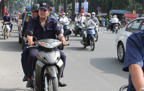 Đoàn lực lượng trật tự đi xe máy nhưng không đội mũ bảo hiểm.