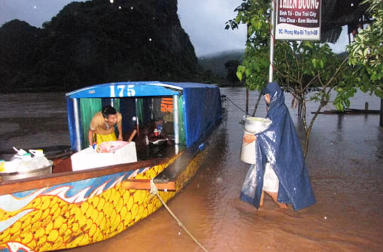 Chuyển đồ đạc lên thuyền đi tránh lũ. Ảnh: Thanh Niên