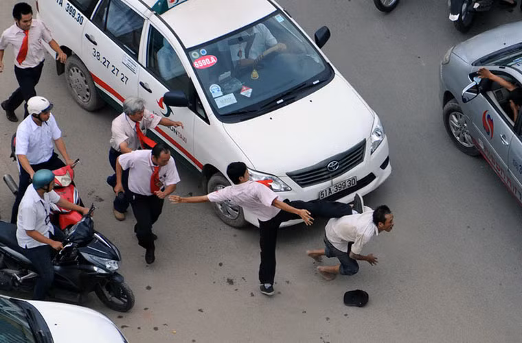 Tài xế xe tải bị các tài xế taxi đánh hội đồng.