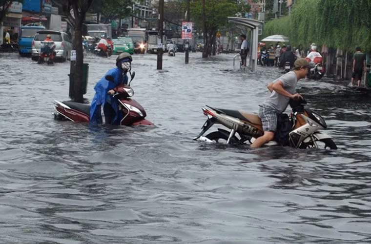 Bì bõm đẩy xe máy giữa biển nước. Ảnh: Tuổi Trẻ
