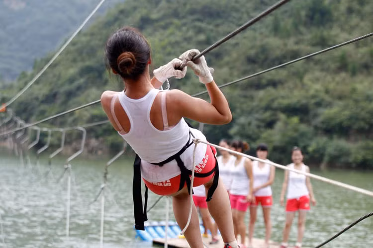 Cô gái trẻ treo mình lên dây cáp trong một bài huấn luyện ở hẻm núi Yuxi.