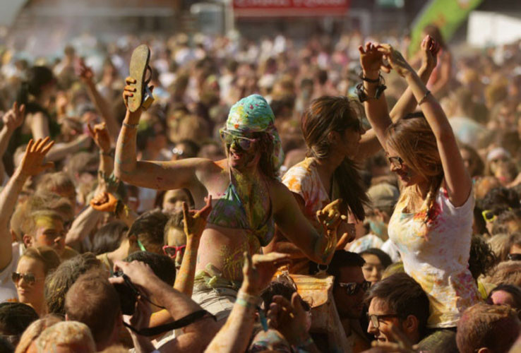 Nhiều cô gái được bạn trai cõng trên vai tham gia lễ hội sắc màu.