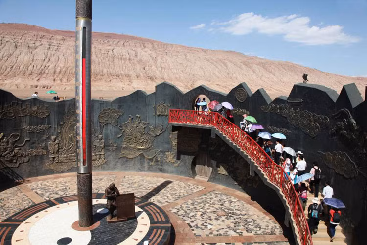 Du khách thăm dãy núi Flaming, Turpan ở khu vực Tân Cương – một trong những nơi nóng nhất thế giới. Nhiệt độ bề mặt ở đây có thể đạt mốc 80 độ C. Trong ảnh, nhiệt độ bề mặt đạt tới mốc 78 độ C.