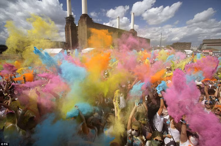 Những người tham gia lễ hội sắc màu đồng loạt tung các gói bột sặc sỡ màu sắc lên không khí, hoặc ném vào nhau, tạo nên một bầu không khí bảy sắc cầu vồng.