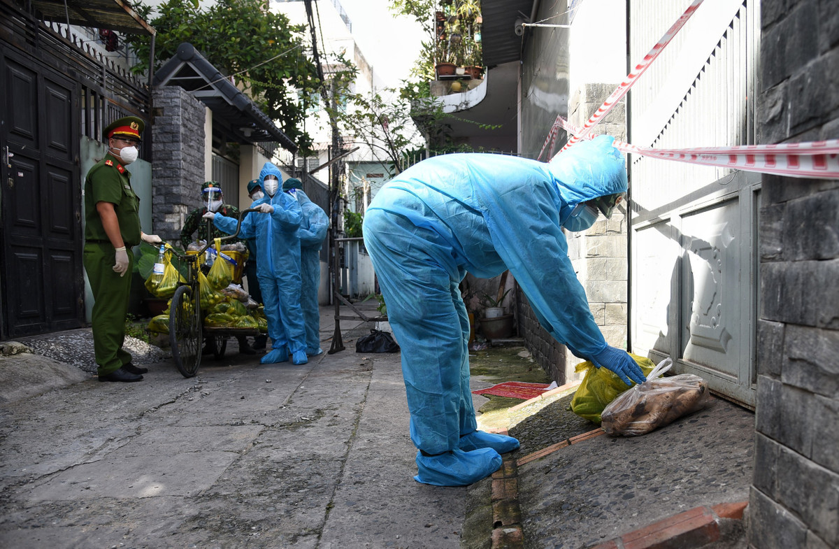 Chính quyền địa phương đã treo biển thông báo và chăng dây phong tỏa trước cửa nhà những hộ dân này. Bộ đội đặt thực phẩm trước cửa rồi gọi gia đình ra nhận.