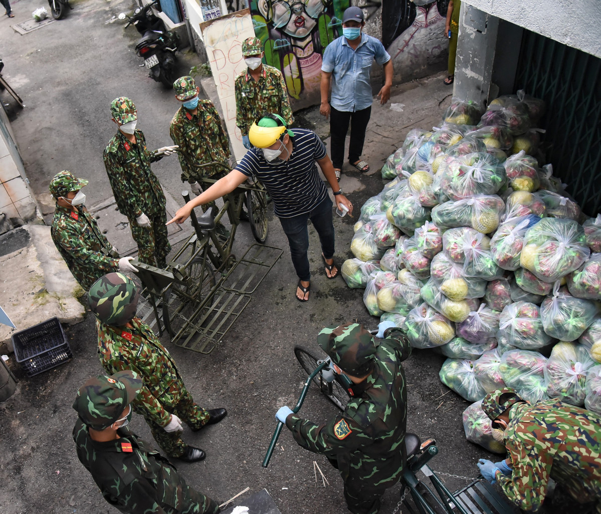 Chiều 1/9, phường 3 (quận Bình Thạnh) huy động 8 chiến sĩ Sư đoàn 5 cùng 2 xe đạp thồ chuyển nhu yếu phẩm đến cho 250 hộ dân.