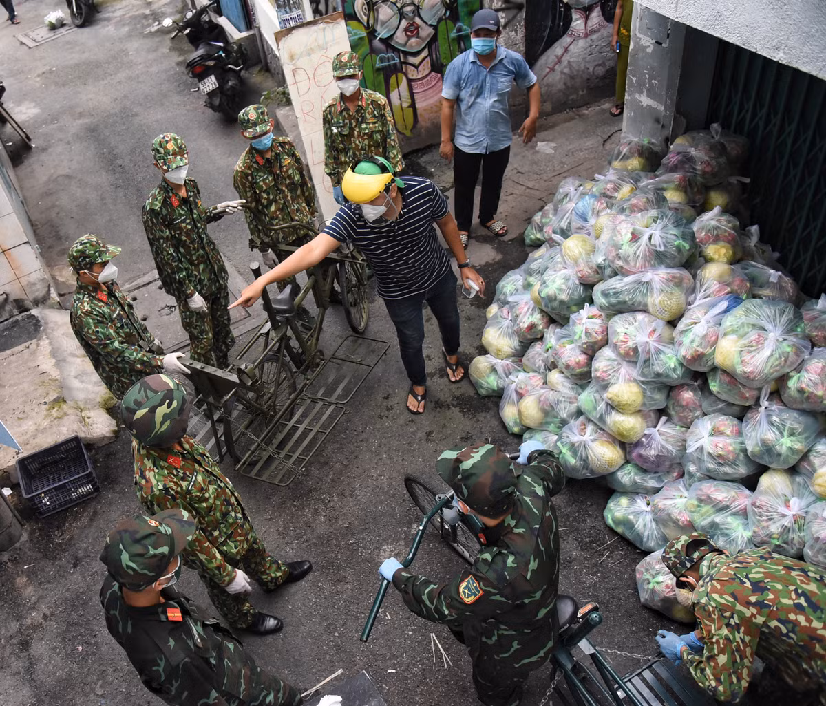 Chiều 1/9, phường 3 (quận Bình Thạnh) huy động 8 chiến sĩ Sư đoàn 5 cùng 2 xe đạp thồ chuyển nhu yếu phẩm đến cho 250 hộ dân.