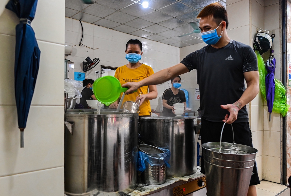 Từ tờ mờ sáng, nhân viên một số cửa hàng bán đồ ăn trên phố Ngọc Lâm (quận Long Biên) tất bật dọn dẹp, chuẩn bị đón khách sau chuỗi ngày dài tạm đóng cửa để phòng chống dịch Coivd-19.