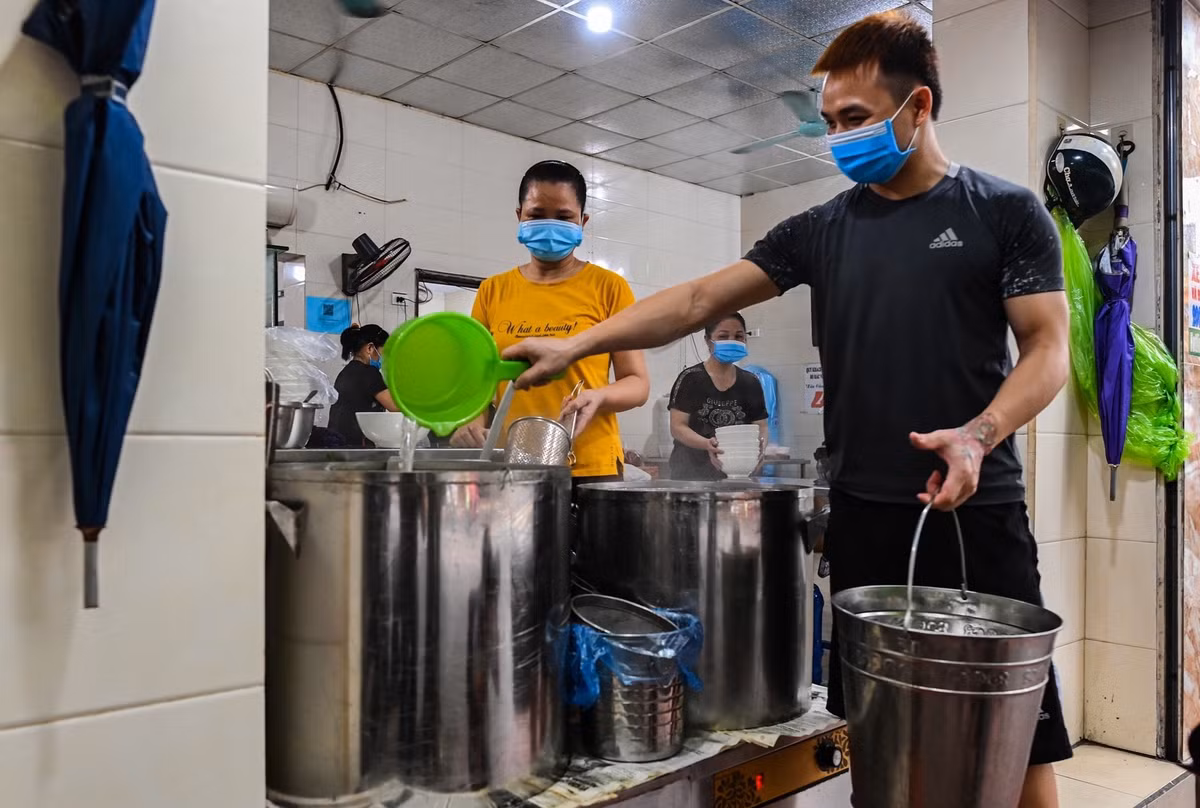 Từ tờ mờ sáng, nhân viên một số cửa hàng bán đồ ăn trên phố Ngọc Lâm (quận Long Biên) tất bật dọn dẹp, chuẩn bị đón khách sau chuỗi ngày dài tạm đóng cửa để phòng chống dịch Coivd-19.