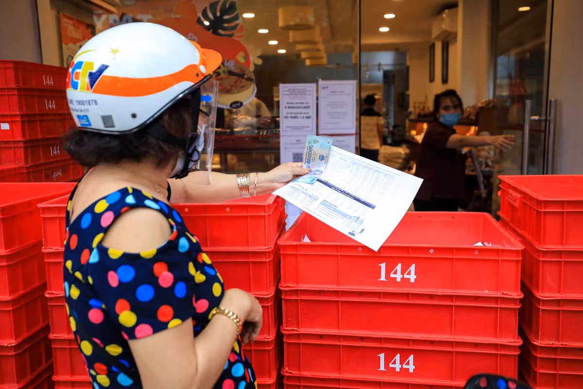 Bà Bảy (quận 4) mua hàng tại tiệm bánh Givral trên đường Khánh Hội. Theo bà, năm nay khách hàng có rất ít lựa chọn và cũng chỉ tranh thủ lúc đi tiêm chủng mới mua được.