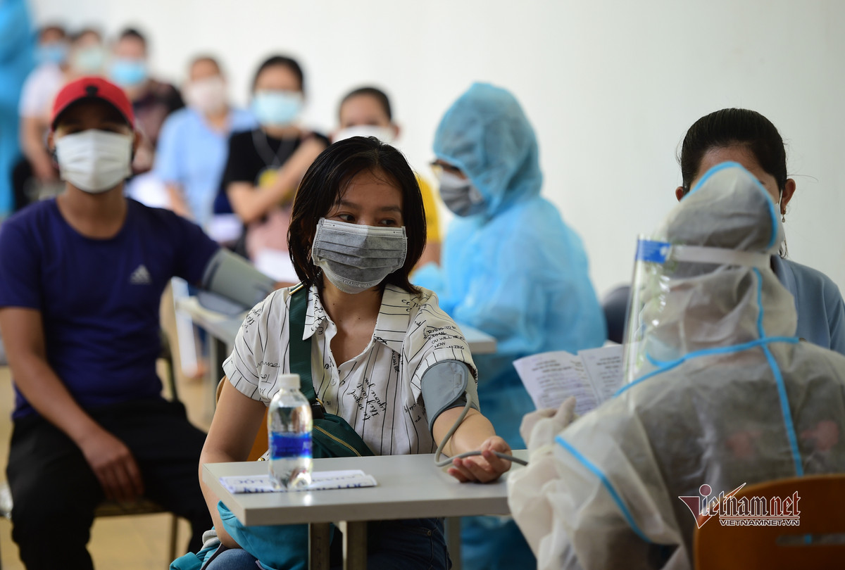 Công nhân được đo huyết áp trước khi tiêm