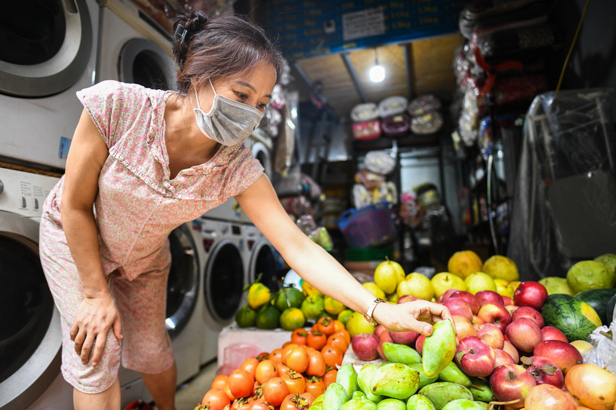 Tiệm giặt là của gia đình bà Quỳnh Mai trên phố Yên Hòa (Cầu Giấy), trước dịch chưa từng buôn bán hàng nông sản. Từ khi thành phố thực hiện giãn cách xã hội, bà quyết định đóng cửa lấy hoa quả về bán cho đến bây giờ, tính ra gần 2 tháng. "Mới đầu tôi cũng không nghĩ là có duyên bán hàng, chuyển sang kinh doanh mặt hàng này do muốn trang trải tiền thuê nhà, tiền chi tiêu sinh hoạt cho cả gia đình vốn rất đắt đỏ. Nay bán hơn tháng trời thì cũng thành quen", bà Mai nói.