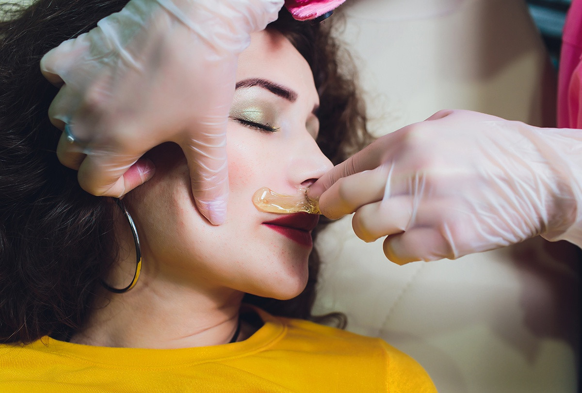 Waxing là phương pháp tẩy lông nhanh chóng, không chỉ giúp loại bỏ lông mà còn làm sạch tế bào chết, bụi bẩn trên da. Tương tự phương pháp luồn chỉ, waxing gây đau đớn và mẩn đỏ nếu da bạn nhạy cảm. Trước khi bắt đầu, bạn làm nóng một ít sáp và thoa lên vùng môi trên. Khi sáp nguội, kéo mạnh nó theo hướng ngược lại với chiều lông mọc. Ảnh: ITW Performance Polymers.