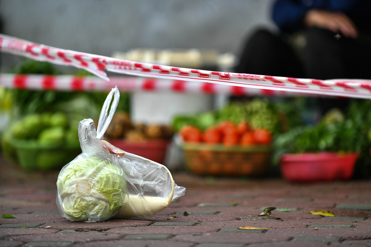 Để hạn chế tiếp xúc, một khách hàng yêu cầu đặt rau củ và tiền thừa xuống đất, không tiếp xúc trực tiếp.