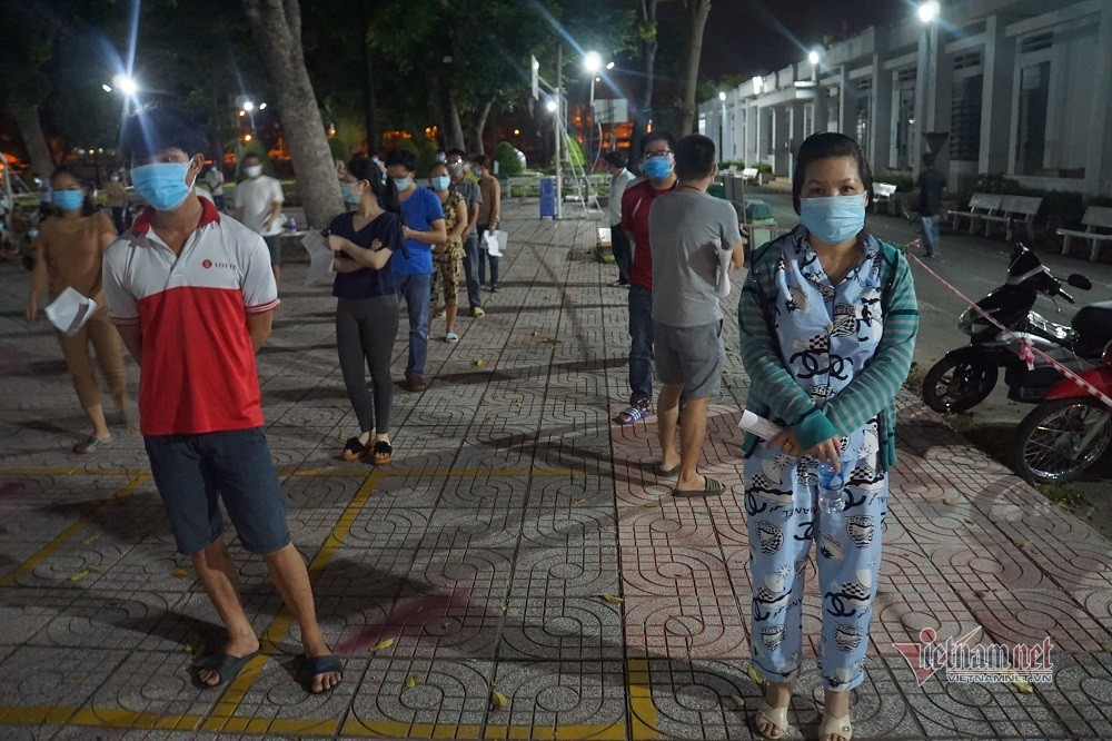 Theo ghi nhận, từ 19h tối, người dân từ các khu phố bắt đầu đổ về điểm tiêm trường THPT Trường Chinh để làm thủ tục vào bên trong. Mặc dù số lượng đông nhưng mọi người đều tuân thủ quy định phòng dịch, xếp hàng trật tự.