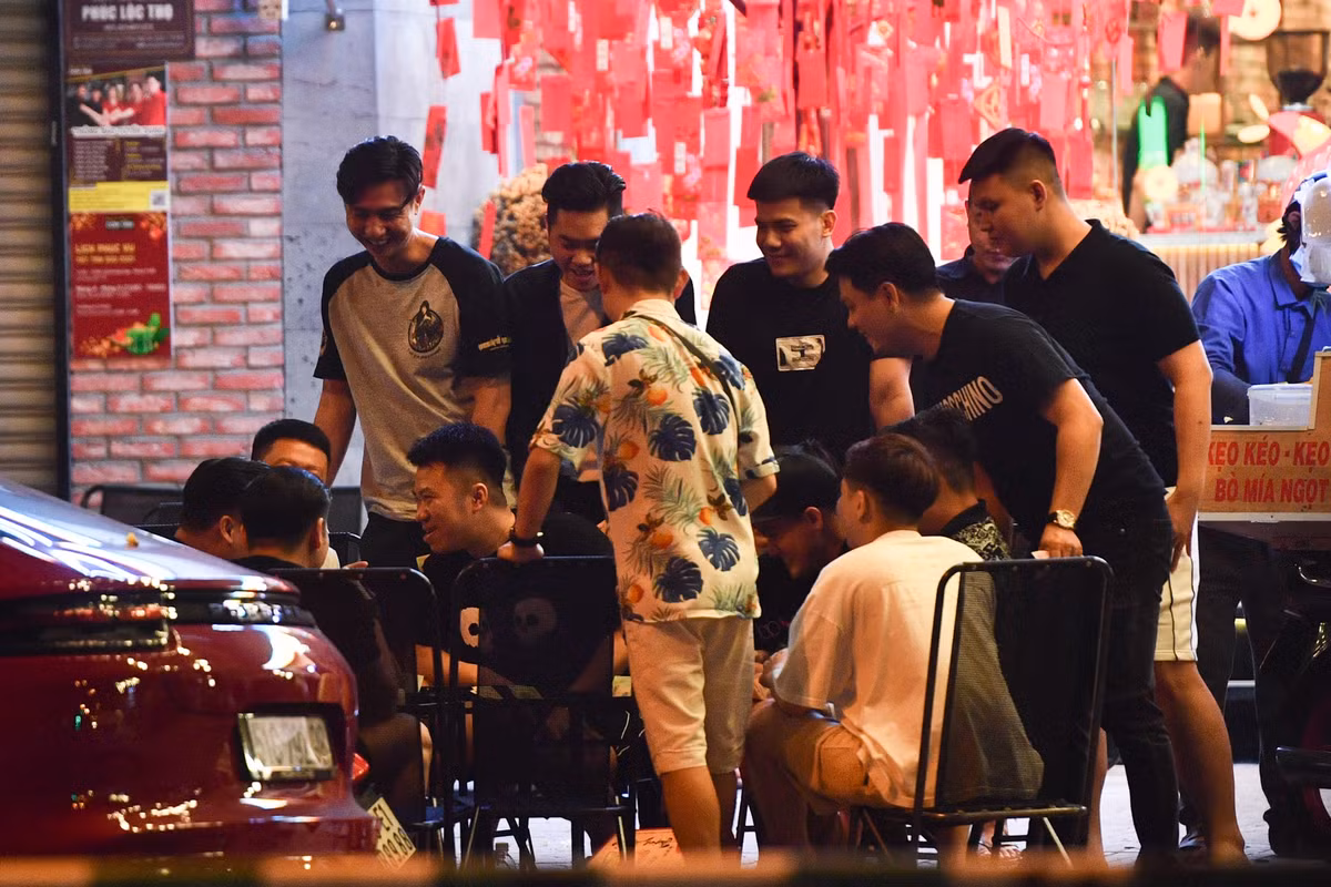 Ngoài quán nhậu, nhiều quán cà phê cũng rất đông khách. Một nhóm khách tụ tập, nói chuyện trên vỉa hè ở một quán cà phê trên đường Quách Thị Trang (quận 1) lúc 0h.