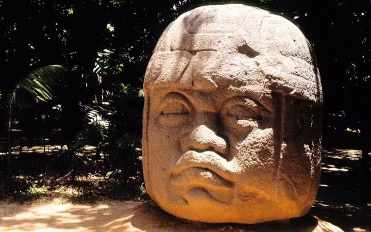 Nằm sâu trong vùng bờ biển vịnh Mexico, những tượng đầu khổng lồ của người Olmec là một trong những di tích cổ đại kỳ bí và ấn tượng nhất từng được phát hiện. Với niên đại hơn 3.000 năm, những tác phẩm điêu khắc bằng đá bazan này không chỉ gây tò mò về cách chúng được tạo ra mà còn đặt ra những câu hỏi lớn về vai trò và ý nghĩa của chúng trong văn hóa Olmec cổ đại. 