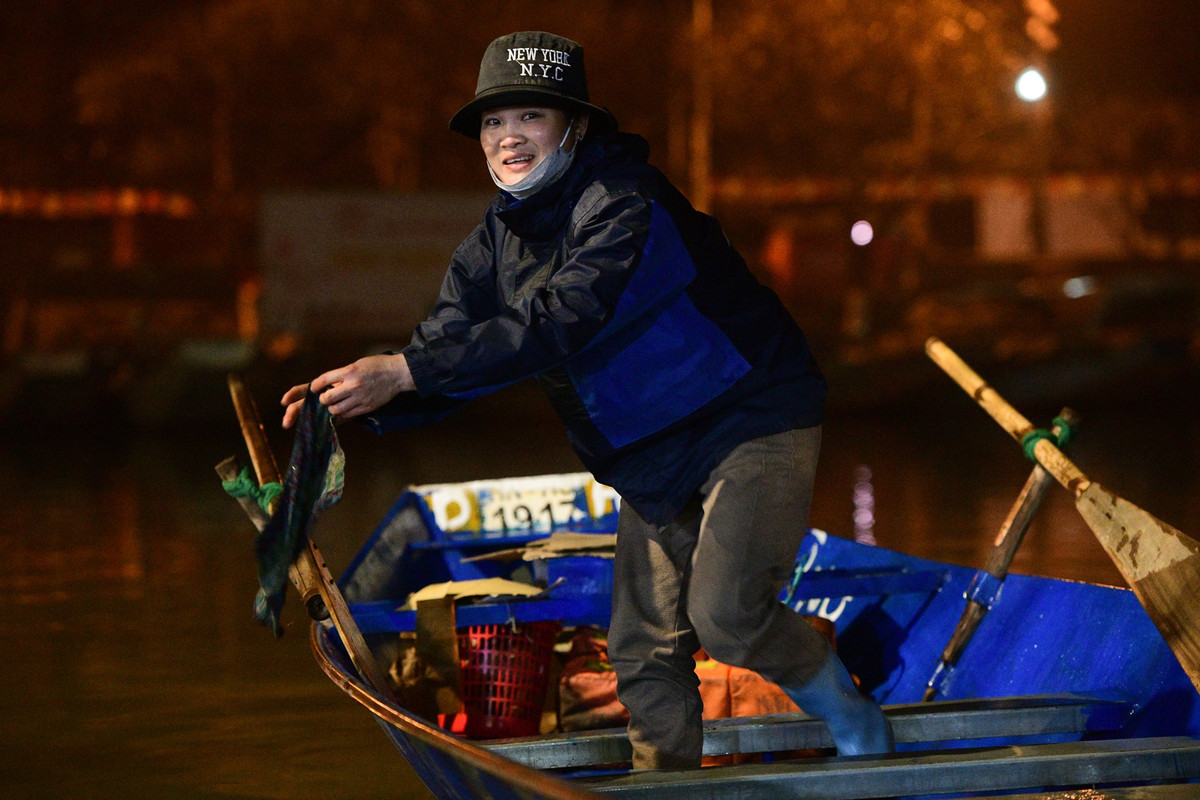 Chị Cường tát nước trên thuyền, lau dọn trong lúc nghỉ ngơi. Làm nghề chèo thuyền tại chùa Hương được 20 năm, chị nhận định dù ảnh hưởng bởi dịch Covid-19 nhưng năm nay lượng khách vẫn sẽ đông đúc.