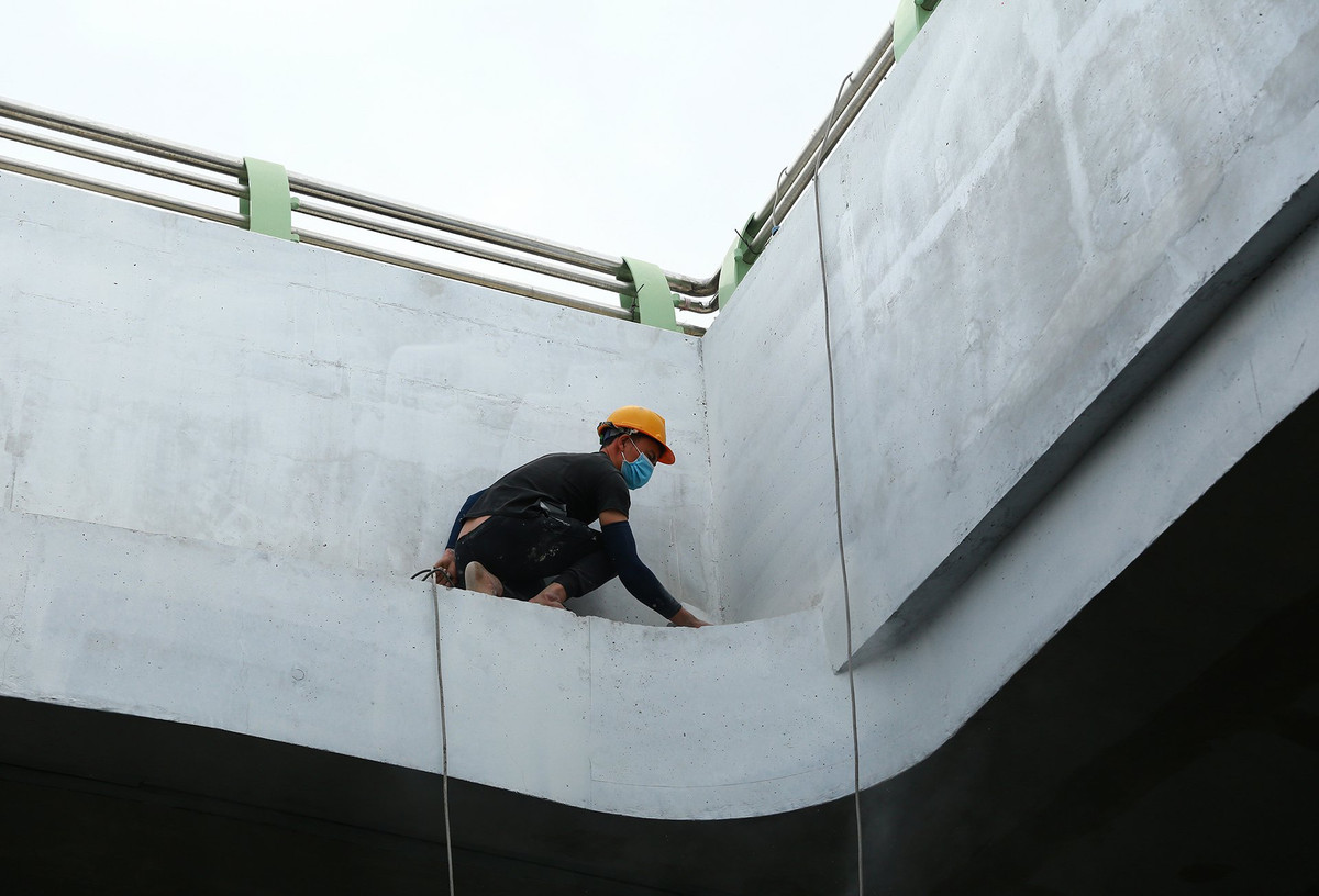 Nhóm công nhân vá lại những chỗ còn khiếm khuyết và hoàn thiện phần trang trí ở thành hầm chui.