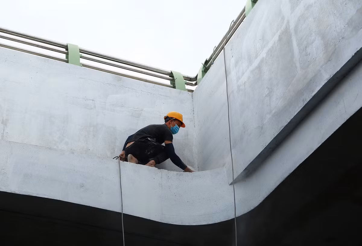 Nhóm công nhân vá lại những chỗ còn khiếm khuyết và hoàn thiện phần trang trí ở thành hầm chui.