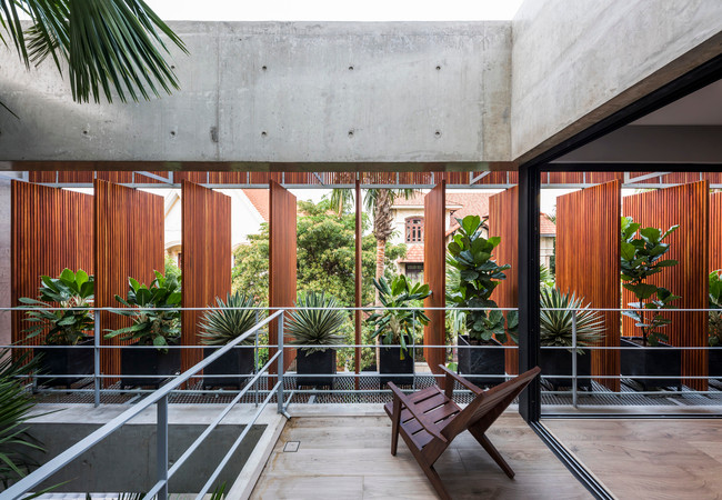 Những lớp cửa này giúp đón ánh nắng và luồng gió tự nhiên một cách dễ dàng, làm bừng sáng không gian bên trong những lớp bê tông tối màu.