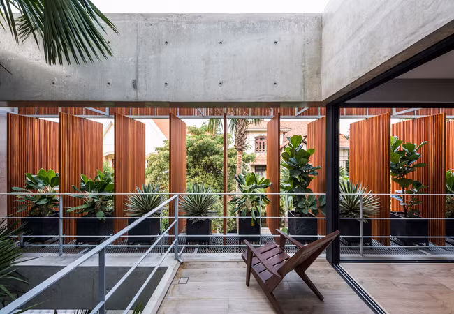 Những lớp cửa này giúp đón ánh nắng và luồng gió tự nhiên một cách dễ dàng, làm bừng sáng không gian bên trong những lớp bê tông tối màu.
