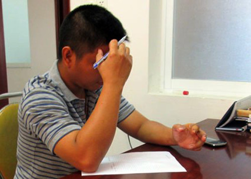 Phạm Hồng Tuân viết bản tường trình tại cơ quan điều tra. Ảnh Khả Trân.