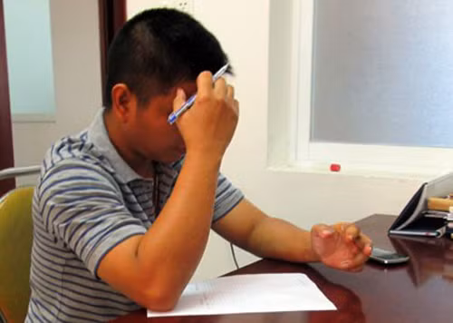 Phạm Hồng Tuân viết bản tường trình tại cơ quan điều tra. Ảnh Khả Trân.