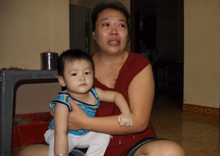 Chị Huệ ôm đứa con trai gần tròn tuổi khóc nghẹn: "Ba nó hứa về làm thôi nôi cho con và mời ông bà nội, ngoại. Vậy mà..." (ảnh TT).
