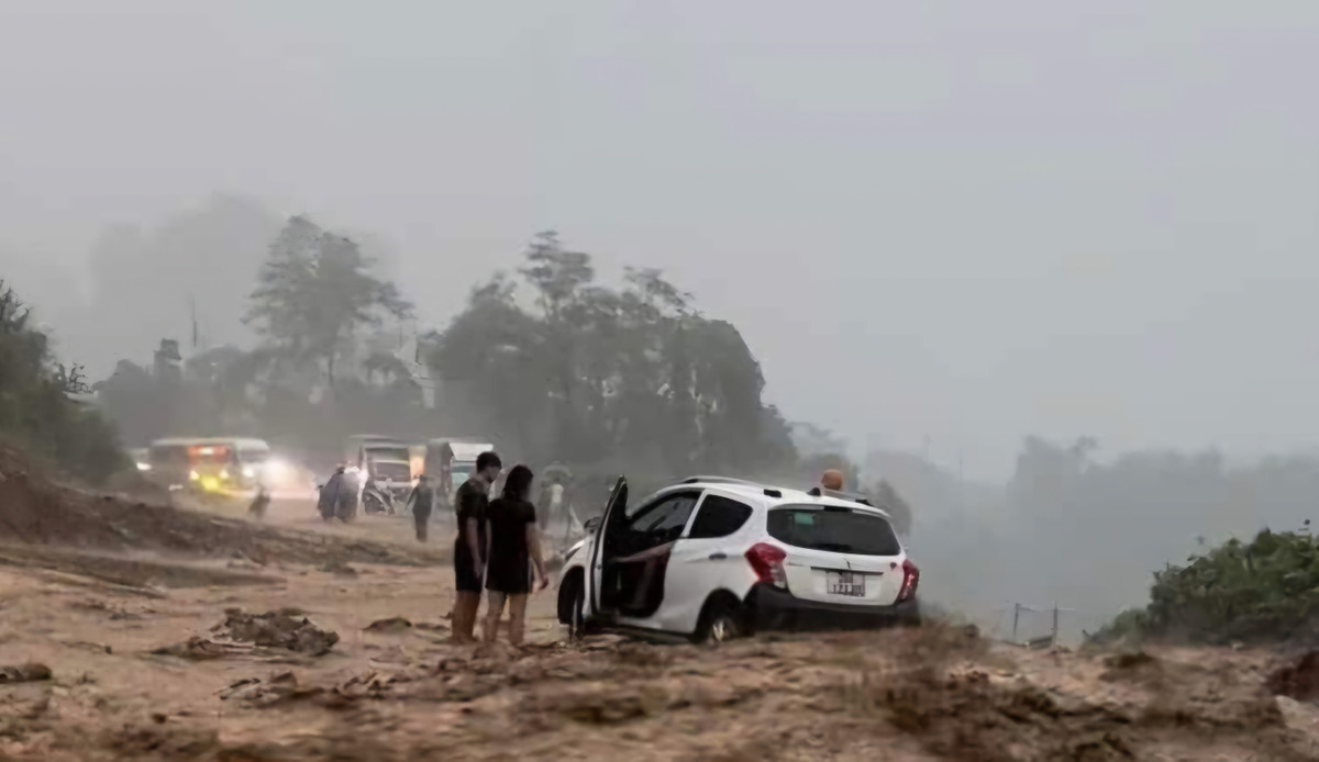 Chiếc xe ô tô của người dân bị nước đẩy gần sát mép taluy âm khi đang cố di chuyển qua đoạn đường nước chảy xiết. Ảnh: Người dân cung cấp.