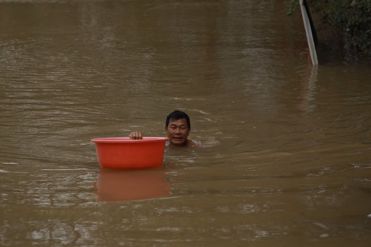 Người dân khổ sở ngụp lặn trong "biển" nước mênh mông.