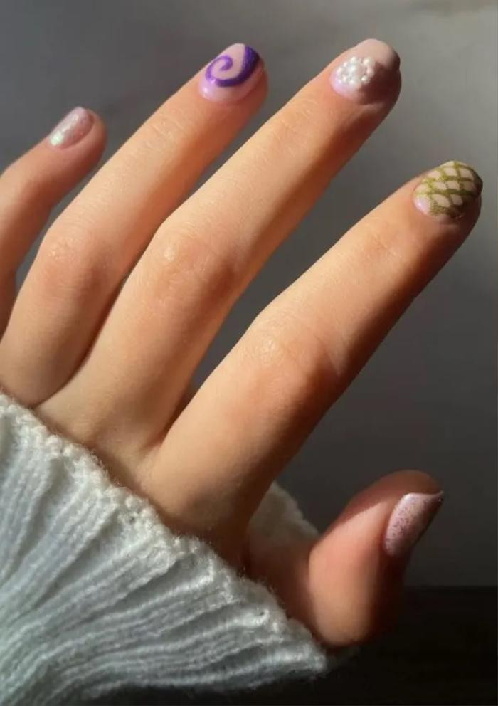  Chiếc “vảy cá” độc đáo: Nếu bạn có móng tay ngắn và mùa hè này bạn muốn đặt cược vào một bộ móng vui vẻ và khác biệt, thì đây là lựa chọn tốt nhất để bạn đạt được điều đó. Được thiết kế cho những người muốn đổi mới, bộ móng bao gồm nhiều kiểu dáng khác nhau, từ những họa tiết nhỏ uốn lượn độc đáo cho đến những bông hoa được đính kết từ ngọc trai, không quên thêm một vài họa tiết vảy cá tạo điểm nhấn. 