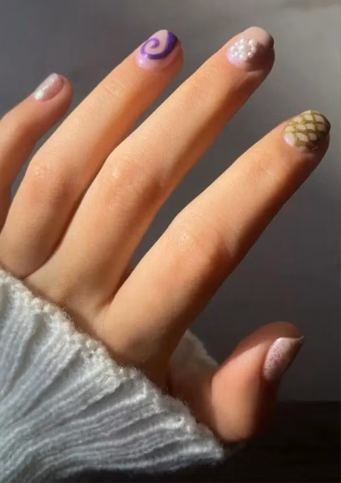  Chiếc “vảy cá” độc đáo: Nếu bạn có móng tay ngắn và mùa hè này bạn muốn đặt cược vào một bộ móng vui vẻ và khác biệt, thì đây là lựa chọn tốt nhất để bạn đạt được điều đó. Được thiết kế cho những người muốn đổi mới, bộ móng bao gồm nhiều kiểu dáng khác nhau, từ những họa tiết nhỏ uốn lượn độc đáo cho đến những bông hoa được đính kết từ ngọc trai, không quên thêm một vài họa tiết vảy cá tạo điểm nhấn. 