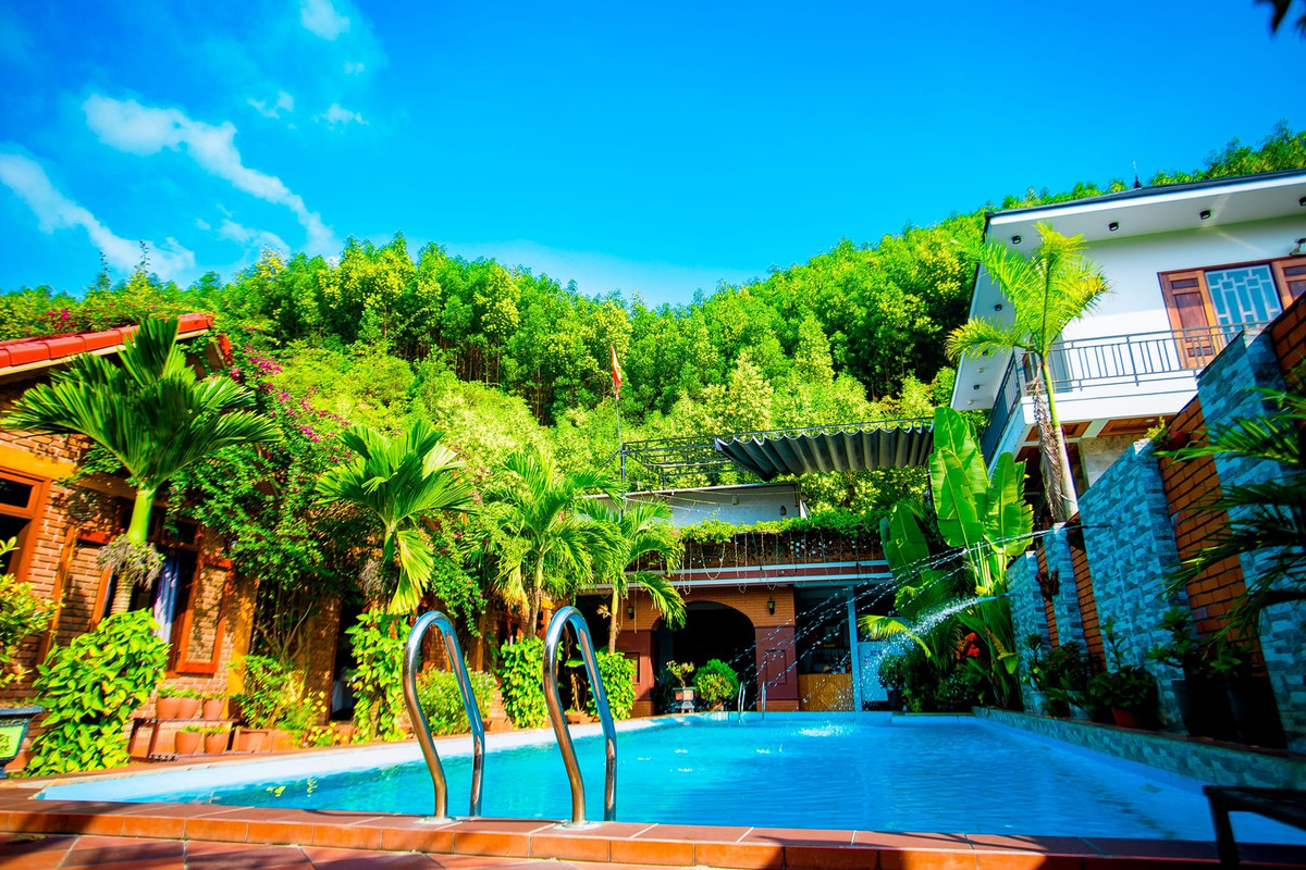 Phong Nha Hillside View Bungalow: Khu nhà nghỉ này bắt đầu hoạt động từ năm 2019. Tọa lạc trên đường mòn Hồ Chí Minh, homestay được xây dựng theo kiến trúc cổ điển với 10 phòng ngủ. Các phòng nghỉ đều có tầm nhìn ra hồ bơi và đồi núi xung quanh. Tại đây có dịch vụ taxi và cho thuê xe máy để du khách có thể đi đến các địa điểm du lịch trong khu vực. Ảnh: Phong Nha Hillside View Bungalow.