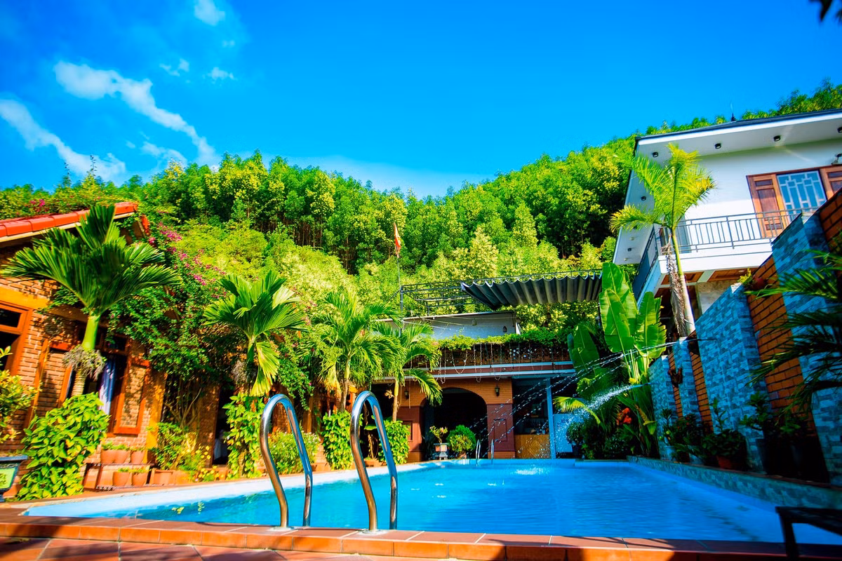 Phong Nha Hillside View Bungalow: Khu nhà nghỉ này bắt đầu hoạt động từ năm 2019. Tọa lạc trên đường mòn Hồ Chí Minh, homestay được xây dựng theo kiến trúc cổ điển với 10 phòng ngủ. Các phòng nghỉ đều có tầm nhìn ra hồ bơi và đồi núi xung quanh. Tại đây có dịch vụ taxi và cho thuê xe máy để du khách có thể đi đến các địa điểm du lịch trong khu vực. Ảnh: Phong Nha Hillside View Bungalow.