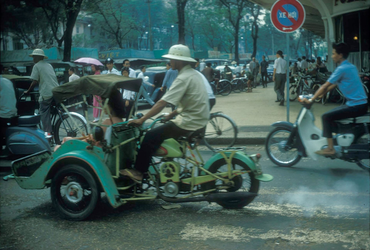 Xích lô máy chạy qua đại lộ Lê Lợi, phía ngoài Thương xá Tax, 1966. Ảnh: Douglas Ross.