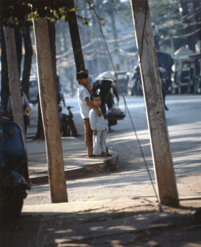 Hai anh em đứng trên vỉa hè.